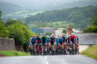 Cyclists approaching hill in group formation at Cadence Road Race round of the Junior Menâ€™s National Road Series.