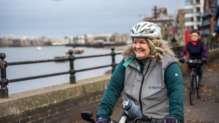 A rider on a riverside path, smiling