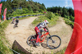 Riders navigating a bend during round 4 of The 2024 Schwalbe British 4X Series at Afan Bike Park, Port Talbot, Wales, United Kingdom